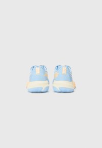 Blue athletic shoes with a soft texture, featuring a cream sole and light orange accents, and a subtle logo detail on the back.