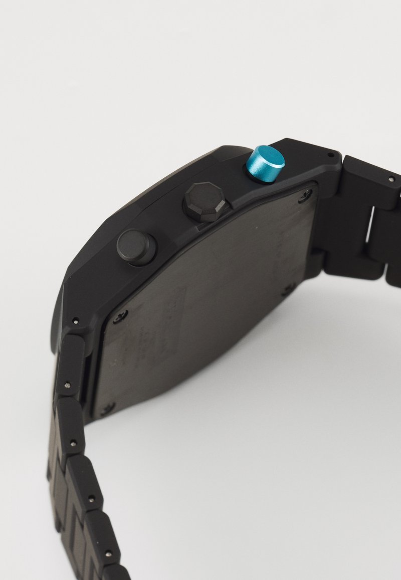 Schwarze Armbanduhr mit quadratischem Ziffernblatt, Metallarmband, runden Knöpfen und blauen Akzenten. Matte Oberfläche mit metallischen Hardware-Details.