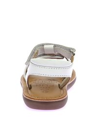 Sandal in pelle bianca con accenti beige, cinturino regolabile e suola in gomma marrone. Plantare testurizzato con logo del marchio impresso.