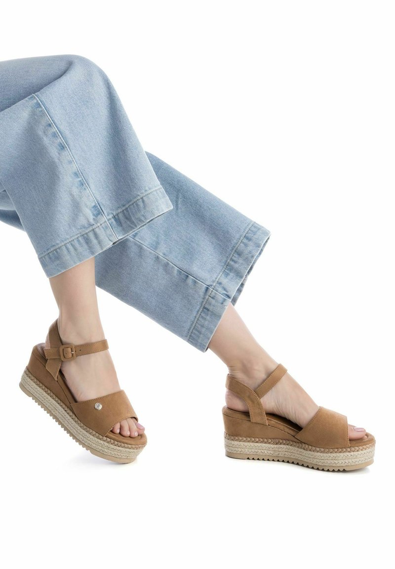 Sandalias de cuña de ante marrón con suela de yute trenzado, diseño de punta abierta, correa ajustable en el tobillo y acabado suave en la parte superior.