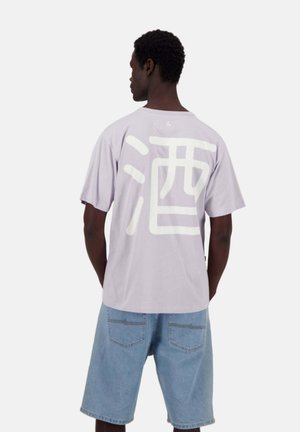 T-shirt viola a maniche corte con grandi caratteri giapponesi bianchi sulla schiena, abbinato a pantaloni corti di jeans blu chiaro.