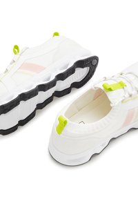 Weiße Sportschuhe aus strukturiertem Stoff mit leuchtend gelben Akzenten, rosa Streifen und einer schwarzen Gummisohle mit einem einzigartigen geschichteten Design.