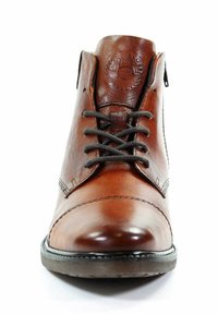 Bottine en cuir marron avec une finition lisse, bout rond, œillets en métal et lacets foncés, arborant un logo embossé sur la languette.