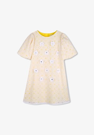 Keltainen kukkakuvioinen mekko, jossa on valkoisia kirjailtuja kukkia, lyhyet pömppöhihat ja pyöreä pääntie. Mekossa on valkoinen pitsireunus.