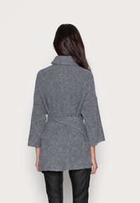 Grijze gebreide cardigan met een brede kraag, een ceintuur in de taille en driekwartmouwen. Heeft een gestructureerd patroon en een middellange stijl.