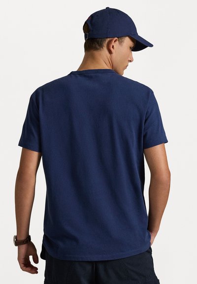 Marineblå bomulls T-skjorte med korte ermer, rund hals og rett nederkant, kombinert med en matchende caps. Enkel design for hverdagsbruk.