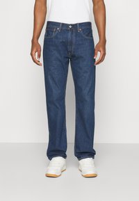 Jeans de mezclilla azul con corte recto, cinco bolsillos, costuras en contraste y cremallera con cierre de botón.