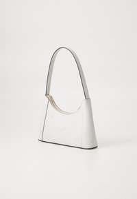 Witte leren schoudertas met een gebogen vorm, gegraveerde bloempatronen en een ritssluiting in gouden tint. Zwarte rand langs de randen.