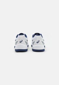Weiße und marineblaue Sportschuhe mit Mesh- und synthetischen Overlays, gepolsterten Sohlen, flachen Schnürsenkeln und Logo-Akzenten an den Seiten und Fersen.