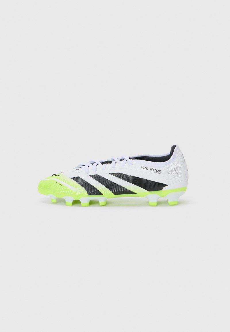 White synthetic soccer cleat with black stripes and a bright green outsole. Features textured detail and a rounded toe for performance.