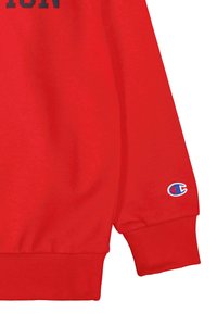 Sudadera roja con puños y dobladillo acanalados, que presenta un pequeño logo bordado en la manga. Textura de tela suave, diseño casual.