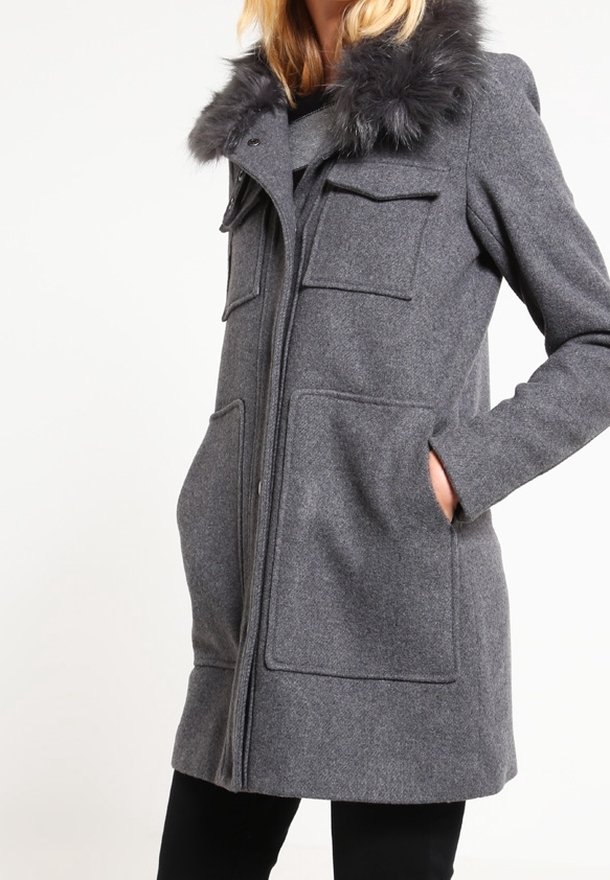 Cappotto grigio con colletto in pelliccia sintetica, due tasche frontali, chiusura con zip e taglio dritto. Realizzato in un tessuto testurizzato simile alla lana.