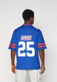 Maillot de football bleu avec des accents rouges, portant le mot "GIANTS" et le numéro "25" au dos, à manches courtes et à col rond.