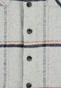 Szara koszula w kratę o fakturze przypominającej wełnę, z czarnymi guzikami oraz pomarańczowymi i granatowymi wzorami w kratę podkreślającymi design.