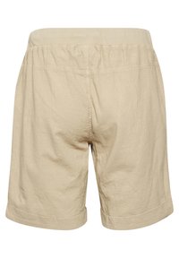 Beige shorts tehtud kergest kangast, pehme elastse pihaosa ja rullitud ääridega, kortsus tekstuur ja lihtne disain.