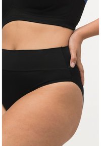 Czarny dwuczęściowy strój kąpielowy z wysokim stanem, o gładkiej fakturze i szerokim pasie. Posiada szew boczny bez widocznych elementów ozdobnych ani wzorów.