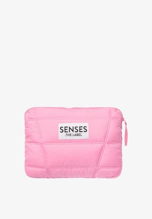 Padded pink laptop sleeve with a textured finish, featuring a white label that reads "SENSES .THE LABEL" and a zip closure.