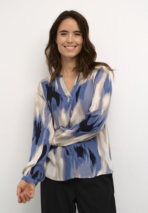 Lange mouwen blouse in tinten blauw en beige met een abstract patroon. V-hals ontwerpe met vloeiende stof en afgeronde zoom.