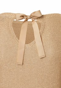 Beige geweven top met een ronde hals en een sleutelgatopening, voorzien van een gestrikt satijnen lint aan de achterkant en een textuur afwerking.