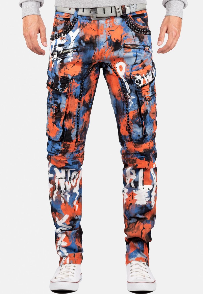 Pantalons cargo avec un motif éclaboussé multicolore en bleu, orange et blanc ; comprenant des zippers, des poches et des accents cloutés.