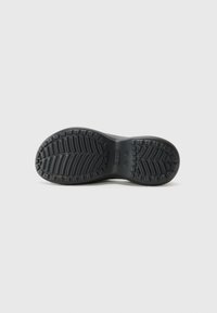 Semelle de chaussure en caoutchouc noir avec un motif de semelle texturé, featuring des rainures et des éléments surélevés pour l'adhérence. Fini lisse avec des bords arrondis.