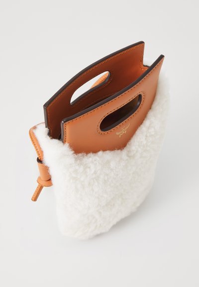 Læder tote taske med to rundede håndtag, med en hvid sartelignende struktur øverst og en rustfarvet læderbund, syede detaljer.