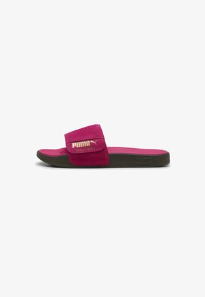 Pink suede slide sandal with a wide strap featuring gold "PUMA PALERMO" branding. Black rubber sole offers flexibility and grip.