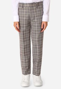 Pantaloni a quadri grigi con una vestibilità su misura, una texture sottile e linee bianche e gialle a contrasto, abbinati a sneakers bianche.