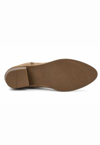 Semelle de chaussure en suède marron avec un petit talon carré, présentant un motif antidérapant texturé à l'avant et une surface lisse sur le reste de la semelle.
