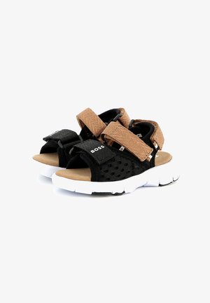 Black and brown sporty sandals with a mesh upper, adjustable straps, and a white rubber sole featuring wave-like texture.