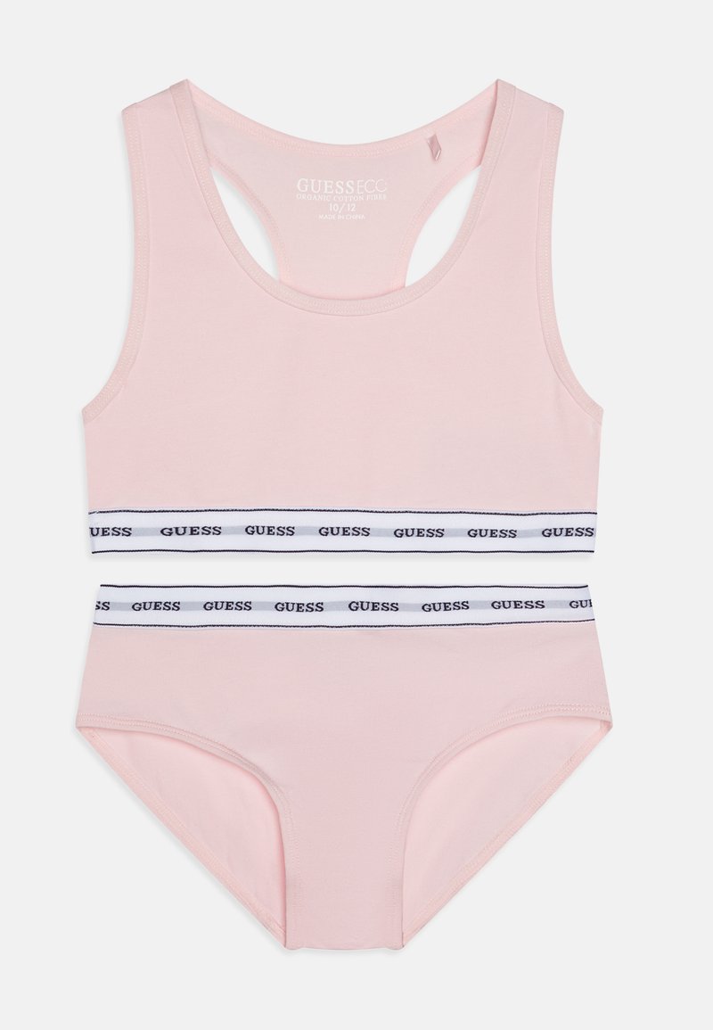 Top na cor rosa com faixa listrada em branco e azul-marinho apresentando o logótipo "GUESS". Feito de algodão orgânico, possui um design com costas em forma de scoop.