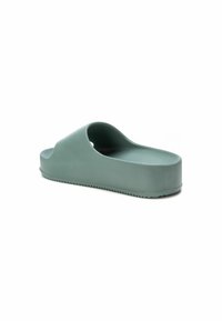 Chancla moldeada de goma suave, con forma superior redondeada, suela gruesa y acabado verde mate con un reverso texturizado.