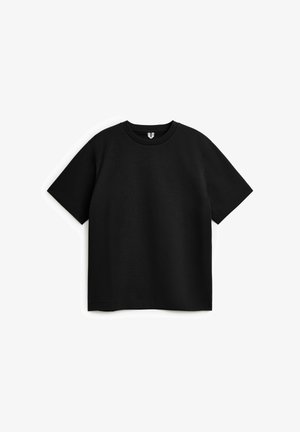 T-shirt noir à manches courtes et col rond posé à plat sur un fond blanc, montrant le devant, sans motifs ni logos visibles.