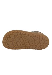 Barfußschuh mit einer flexiblen Gummisohle, die ein Wabenmuster aufweist, in brauner Farbe und mit dem Markendesign 'Lurchi'.
