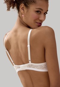Witte kant bralette met verstelbare schouderbanden, bloemenkantdetail op de band, gladde stof, inclusief haak-en-oogsluiting aan de achterkant.