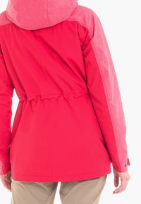 Röd jacka med figursydd midja och texturerad ljusrosa hood. Har slätt tyg, elastisk midja och knappdetalj vid ärmslut.