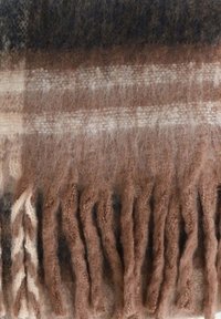 Tessuto di lana a quadri marrone e beige con texture morbida e frange lunghe e spesse lungo il bordo.