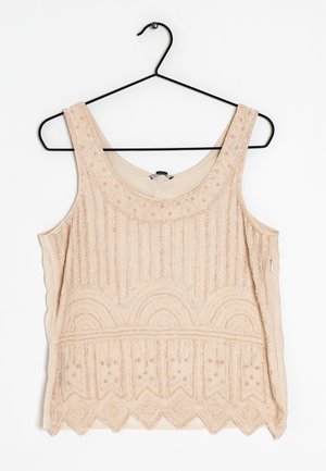 Top in tan con perline, con scollo rotondo, che presenta motivi decorativi e dettagli testurizzati lungo l'orlo e il busto.