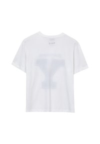 T-shirt bianco a maniche corte con una grande "Y" visibile attraverso il tessuto sul retro e la scritta "YALE" al contrario stampata sul collo.