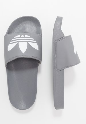 Gray slide sandals made of textured synthetic material with a wide strap featuring a white logo design and a smooth sole.