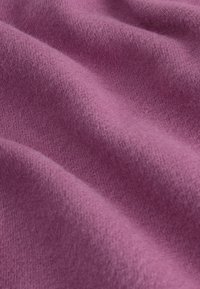 Tela morada con una superficie suave y texturizada, que presenta pliegues y ondas suaves, indicando un material ligero y acolchado.