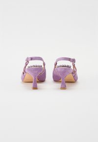 Chaussures à talons hauts en suède violet avec une sangle de cheville, dotées d'un petit talon profilé et d'accents en cristal décoratifs à l'arrière.