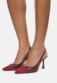 Slingback-höga klackar med spetsig tå, i burgundyläder och mocka, och med en dekorativ guldig accent framtill.