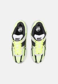 Nike Vomero-sneakers med övre del i nätmaterial i neongul och svarta ränder, med vita detaljer, snören och en vadderad sula.