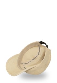 Cappello in corduroy beige chiaro con visiera curvata, dotato di etichetta interna e di una fascia nera regolabile. La texture appare morbida, con cuciture visibili.
