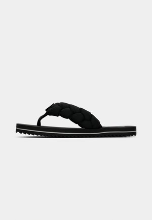 Sorte flip-flop sandaler med flettet stropdesign, tekstureret gummisål med en tandet kant, og en flad, minimalistisk silhuet.