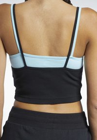 Fekete és világoskék cropped top állítható pántokkal, bordázott mintázattal és kontrasztos színekkel, amely alakformáló sziluettet kínál.