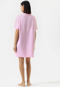 Robe t-shirt oversize rose en coton doux, avec des manches courtes, un col rond et un ourlet droit.