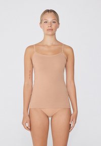 Nude tank top z cienkimi ramiączkami, wykonany z miękkiego, rozciągliwego materiału. Posiada prosty, dopasowany krój i gładką fakturę.
