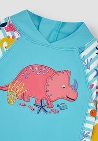 Šviesiai mėlynas vaikiškas rash guard'as su rausvu išsiuvinėtu dinozauru, spalvingais jūros dumblais, žuvimis ir žvaigždėmis šoninėse dalyse, papuoštas dryžuotais akcentais.